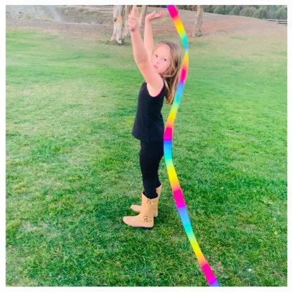 Child playing with a rainbow ribbon wand.